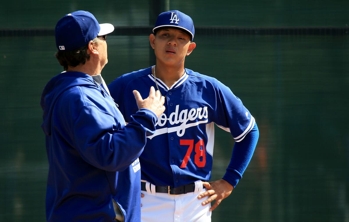 Dodgers pitching coach Rick Honeycutt talks to top prospect Julio Urias (78) at spring training.