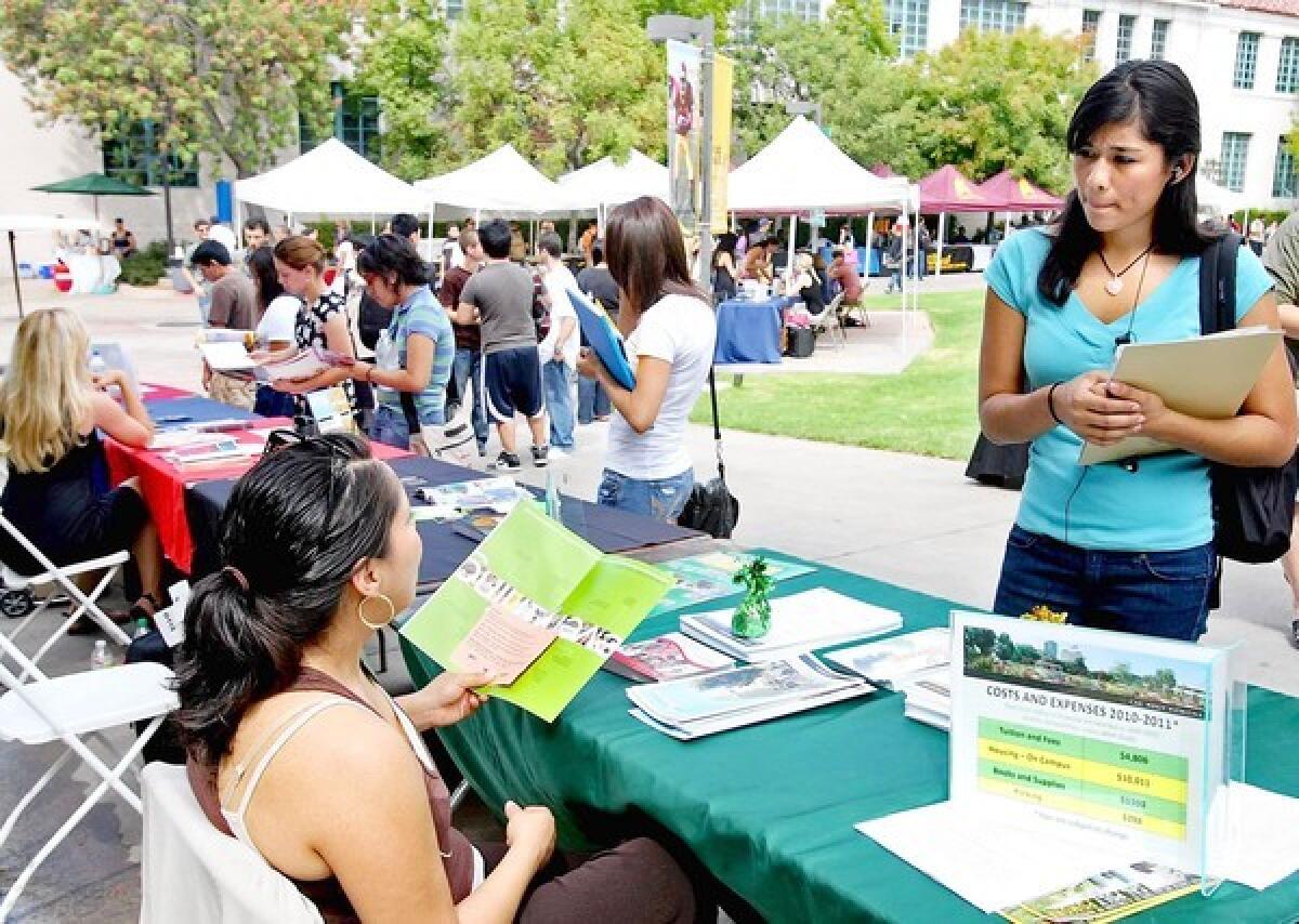 Dulce Guerrero, from Cal Poly Pomona's admissions and outreach, left, talks to Karla Valladares, 19, of L.A., during college transfer fair at the school.