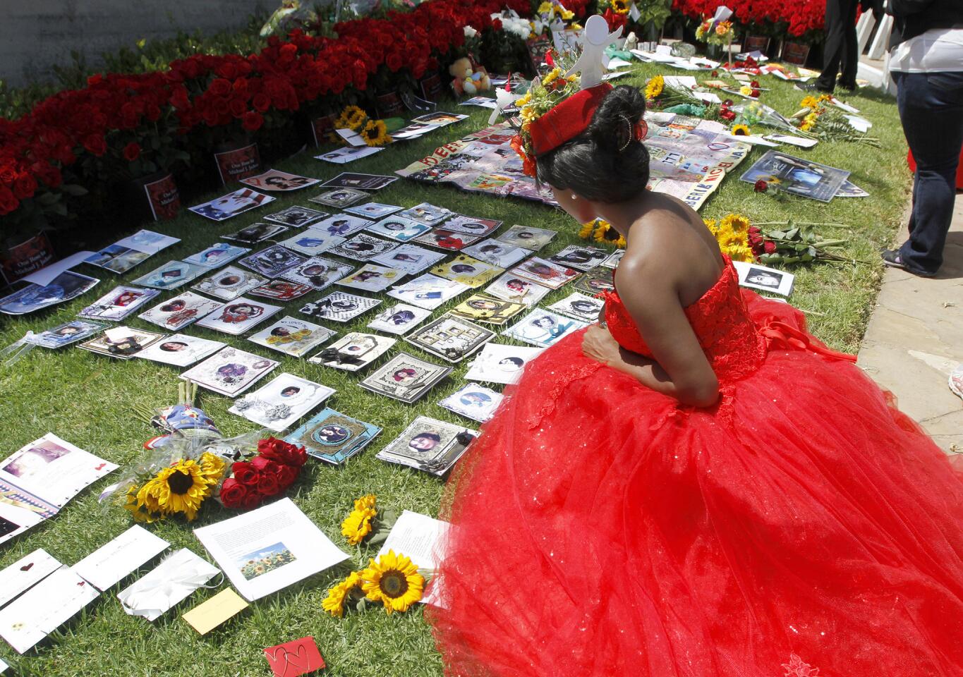 Raquel Jean Joseph of New York looks at items left at the Michael Jackson fan memorial on the 5th anniversary of Jackson's death, at Forest Lawn Memorial Park in Glendale on Wednesday, June 25, 2014. Jackson is buried at the Great Mausoleum at Forest Lawn.