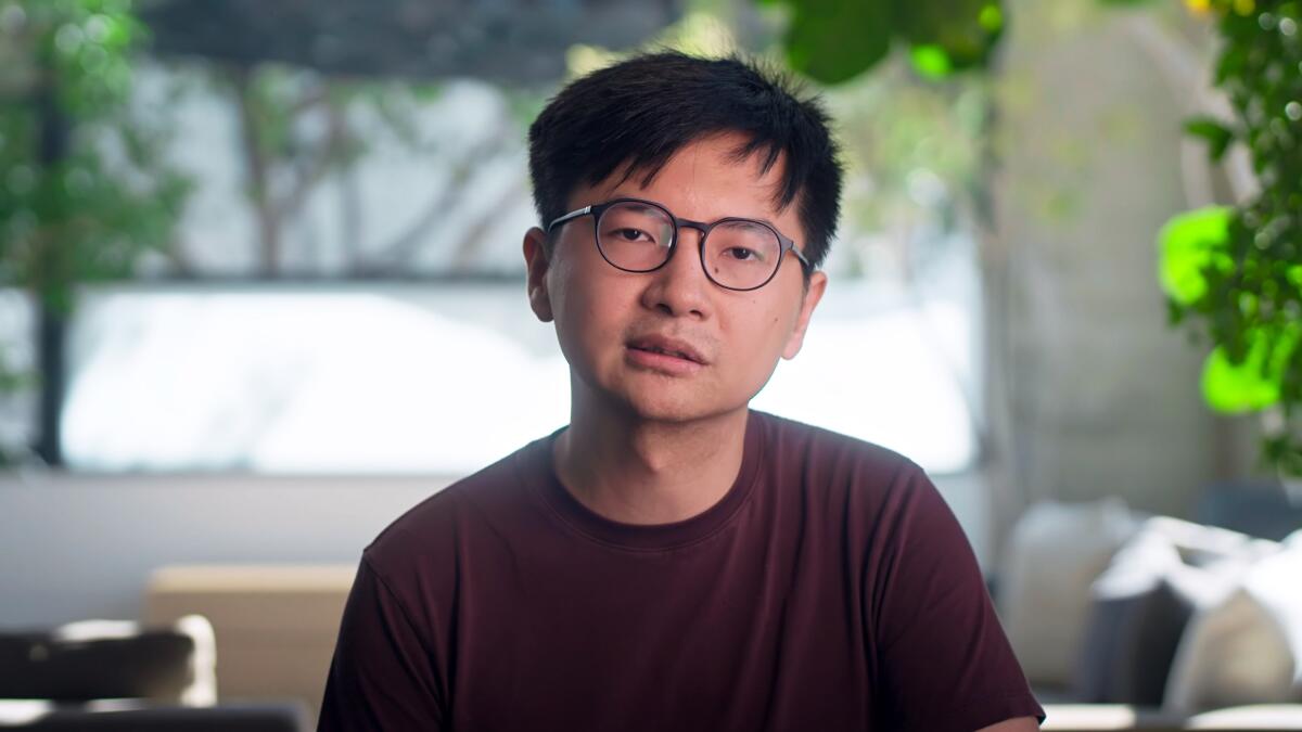 A man in glasses and a maroon T-shirt