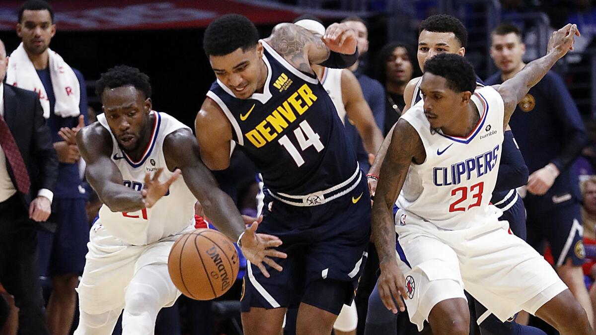Clippers Patrick Beverley, left, and Lou Williams lose control of the ball to Nuggets guard Gary Harris in the fourth quarter.