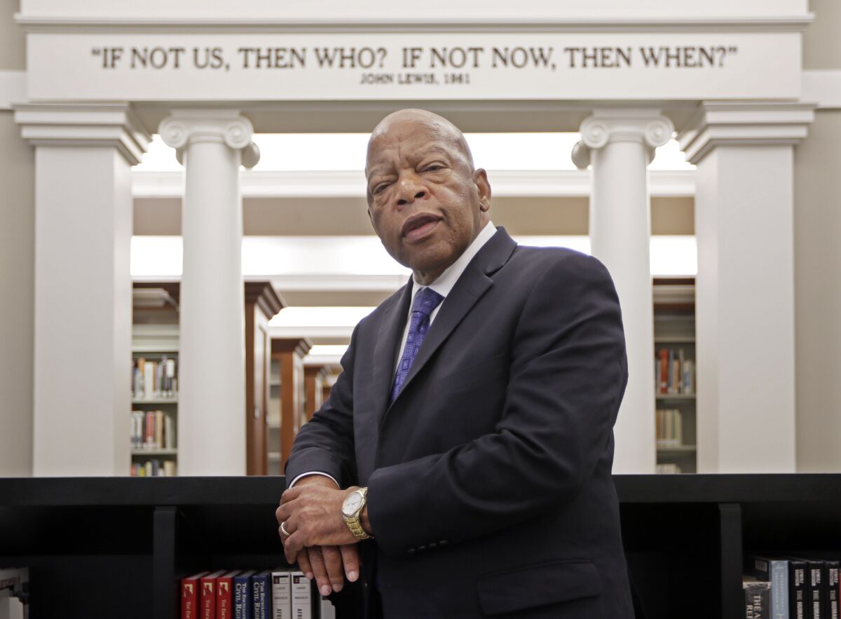 Rep. John Lewis, D-Ga., poses for a photograph under a quote of his that is displayed in the Civil Rights Room in the Nashville Public Library on Nov. 18, 2016.