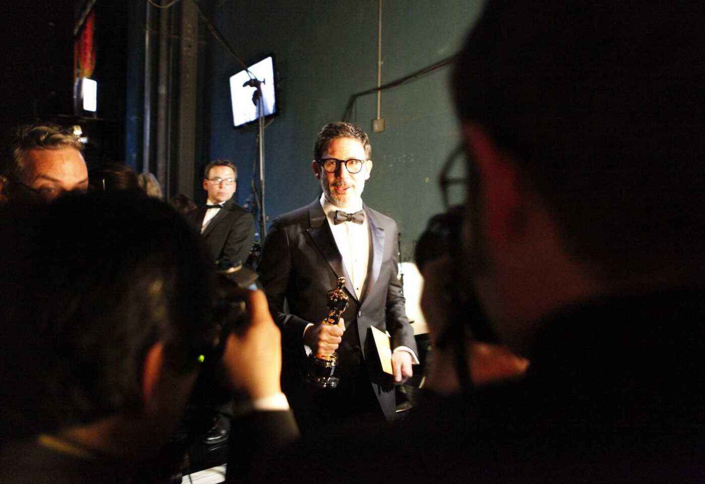 The best director winner ("The Arist") is caught between the stage and the press room at the 2012 Academy Awards in Hollywood.