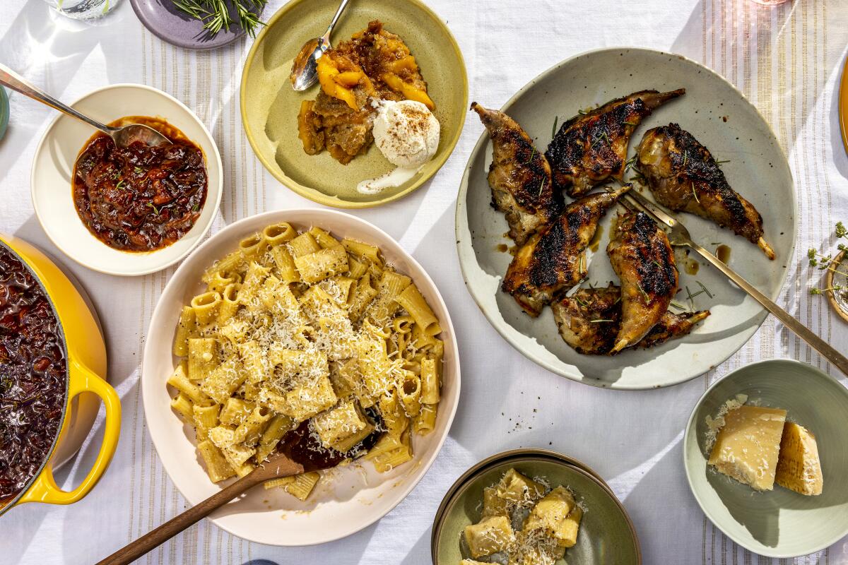 An overhead view of bowls and plates holding dishes including braised rabbit and macaroni and cheese.