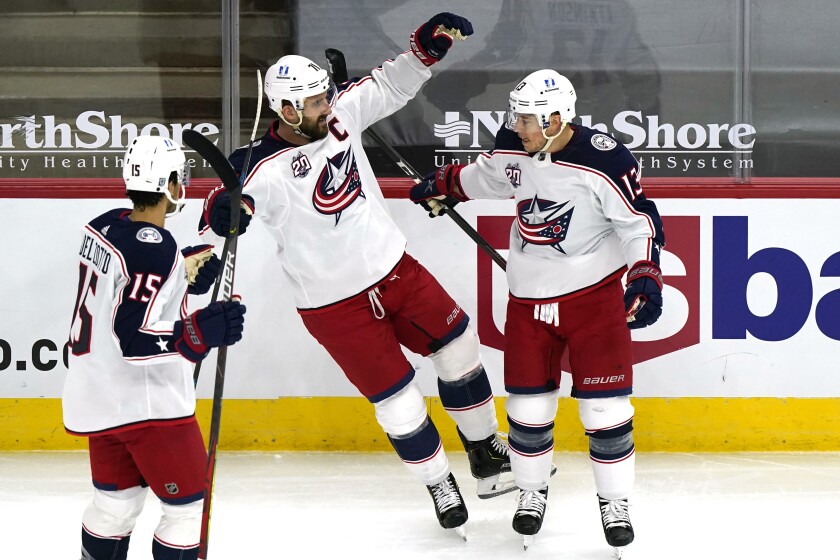 Columbus Blue Jackets right wing Cam Atkinson, right, celebrates with defenseman Michael Del Zotto, left, and left wing Nick Foligno after scoring a goal against the Chicago Blackhawks during the first period of an NHL hockey game in Chicago, Thursday, Feb. 11, 2021. (AP Photo/Nam Y. Huh)