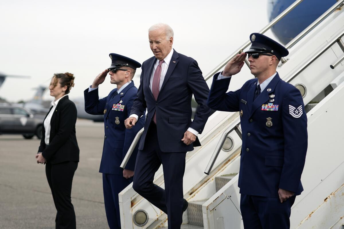 President Biden walks down the steps from Air Force One.