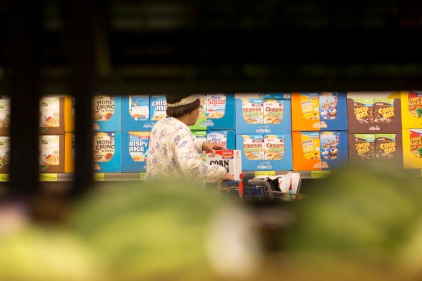 A shopper browses the cereal section at the Aldi food market in Inglewood. Cereal sales have gone flat because of concerns about nutrition and convenience.