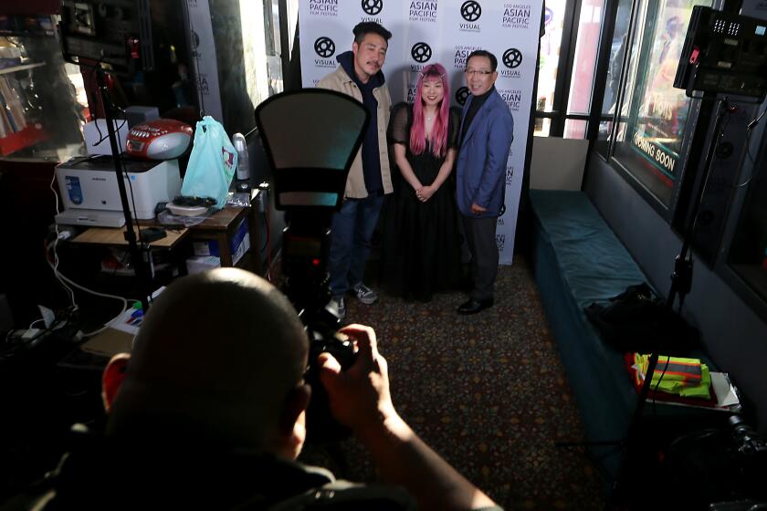 Gardena, CA - May 10: Filmmaker So Yun Eum, center, poses for pictures before the L.A. premier of her documentary. The film is called called Liquor Store Dreams, and features her father, Hae Sup Eum, right, and Danny Park, left,. So Yun Eum is a second generation Korean American and the film is about the Korean American merchant class. (Luis Sinco / Los Angeles Times)