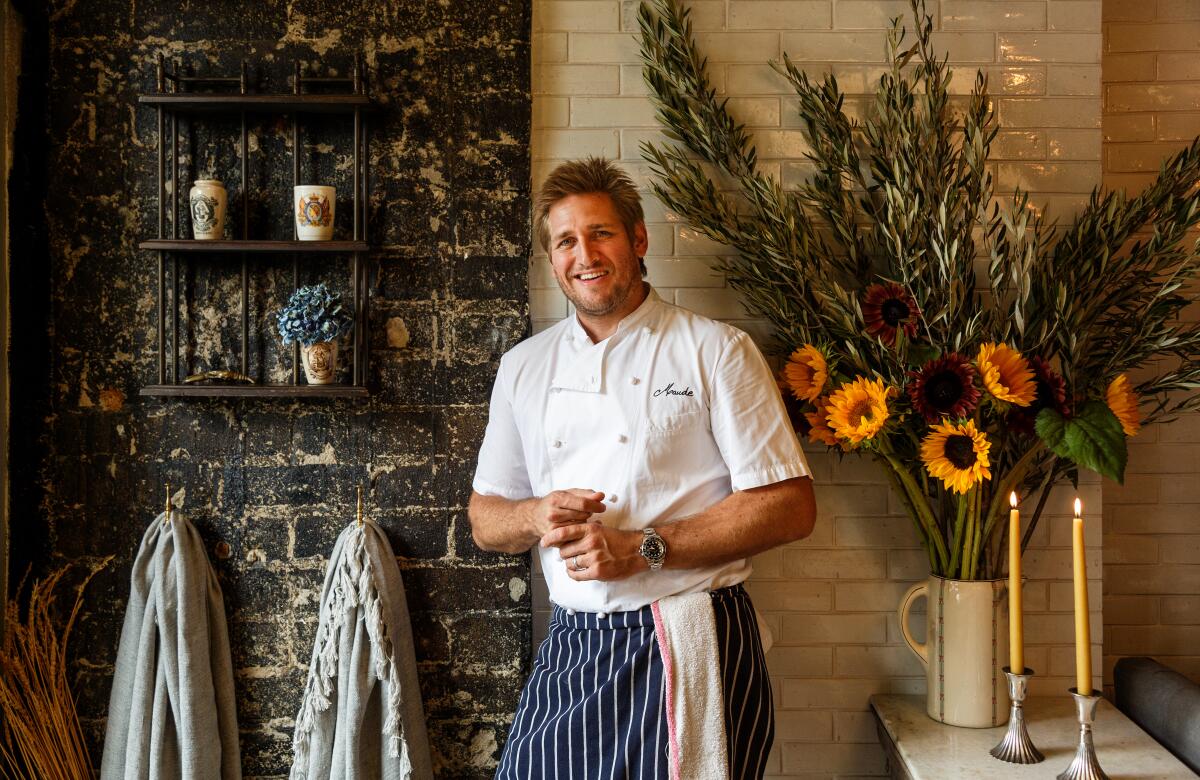 Chef Curtis Stone standing against a wall inside his restaurant Maude in 2015.