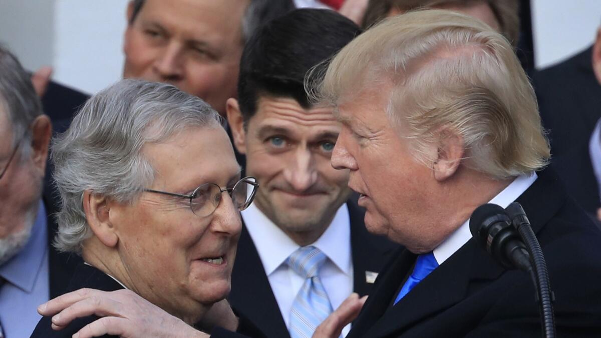 Bad for your health: President Trump congratulates Senate Majority Leader Mitch McConnell, left, while House Speaker Paul Ryan looks on in glee over the tax cut bill, which Texas and 19 other states claim invalidates Obamacare's protections for preexisting conditions.