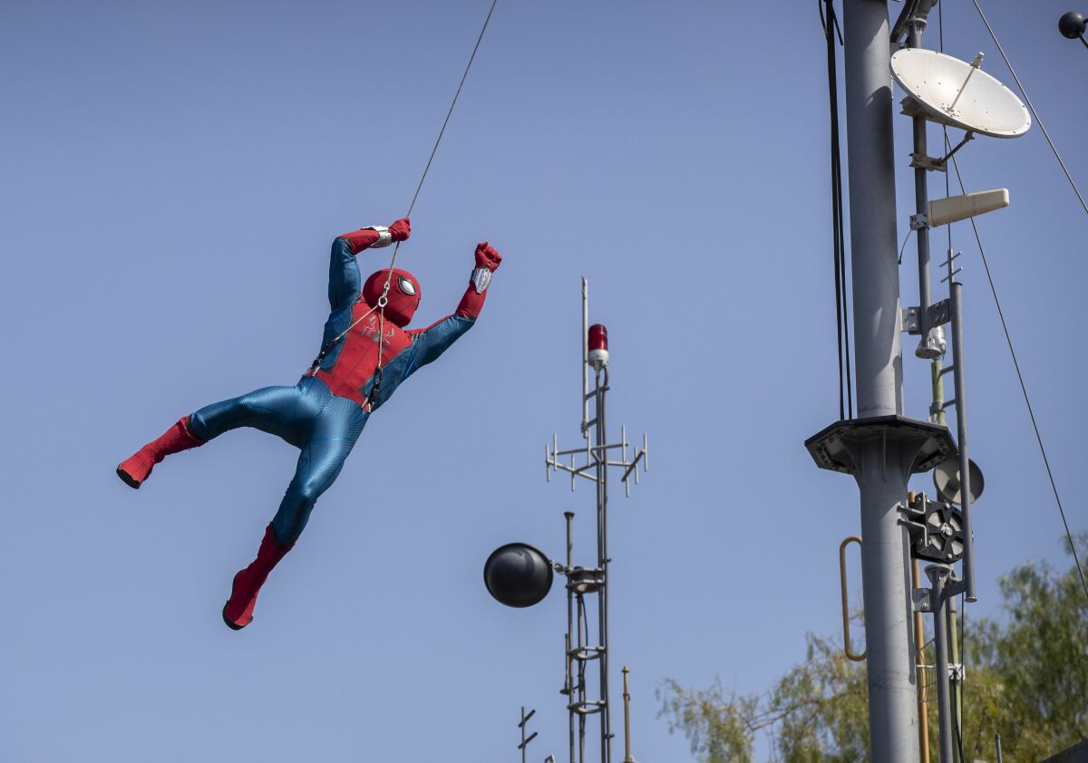 A robot Spider-Man soars through the air while performing