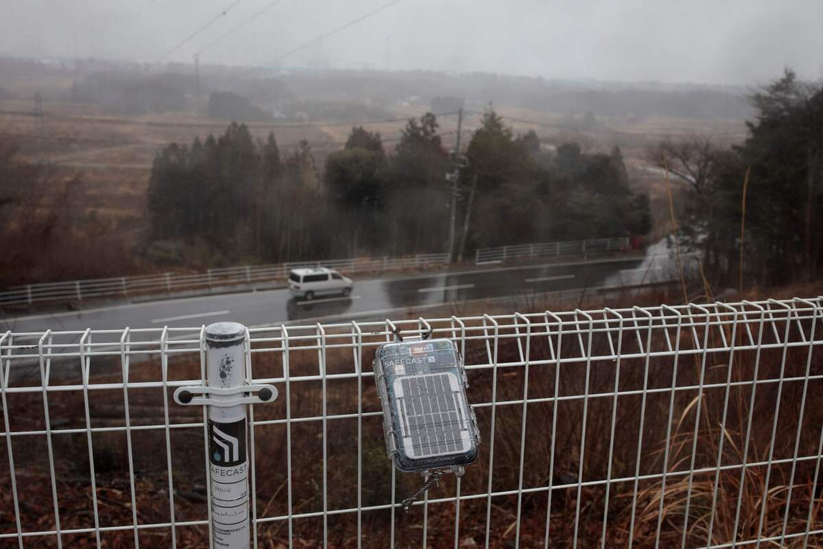 Geiger counter attached to fence near Daiichi nuclear power plant in Fukushima