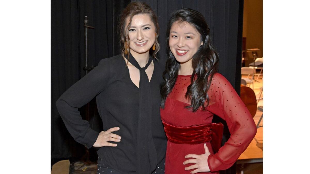 Fashion design student Katrin Divinets, left, with harpist Alyssa Katahara wearing the red silk and chiffon gown Divinets created for her.