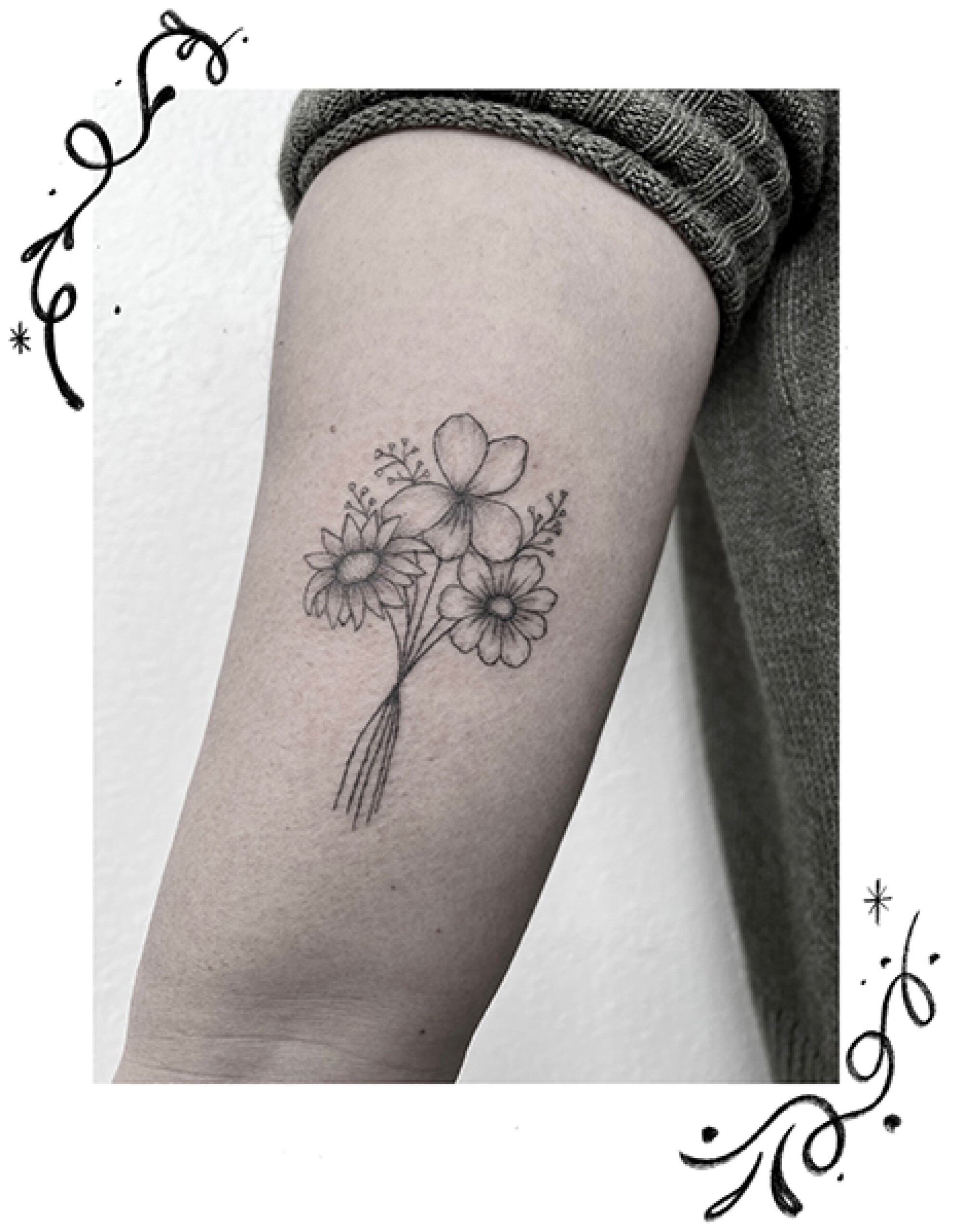Birth flower tattoos on an arm.