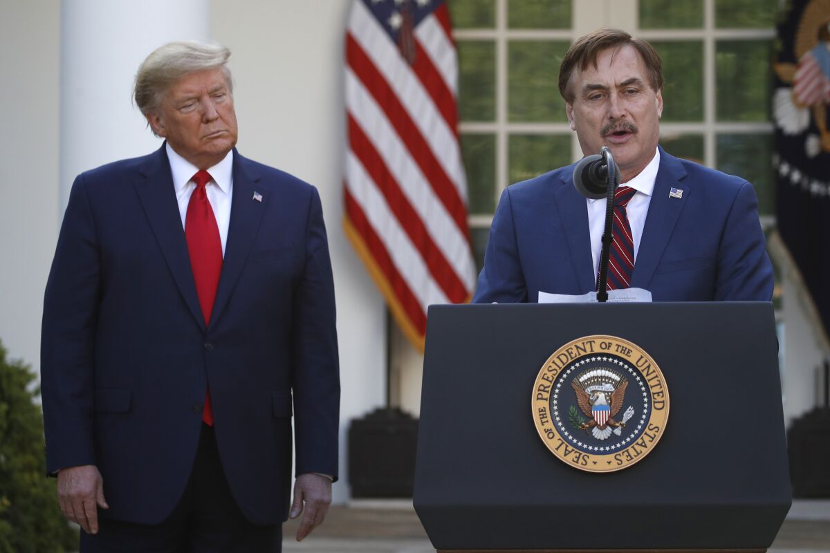 My Pillow CEO Mike Lindell, right, speaks as President Trump listens during a briefing about the coronavirus in March.
