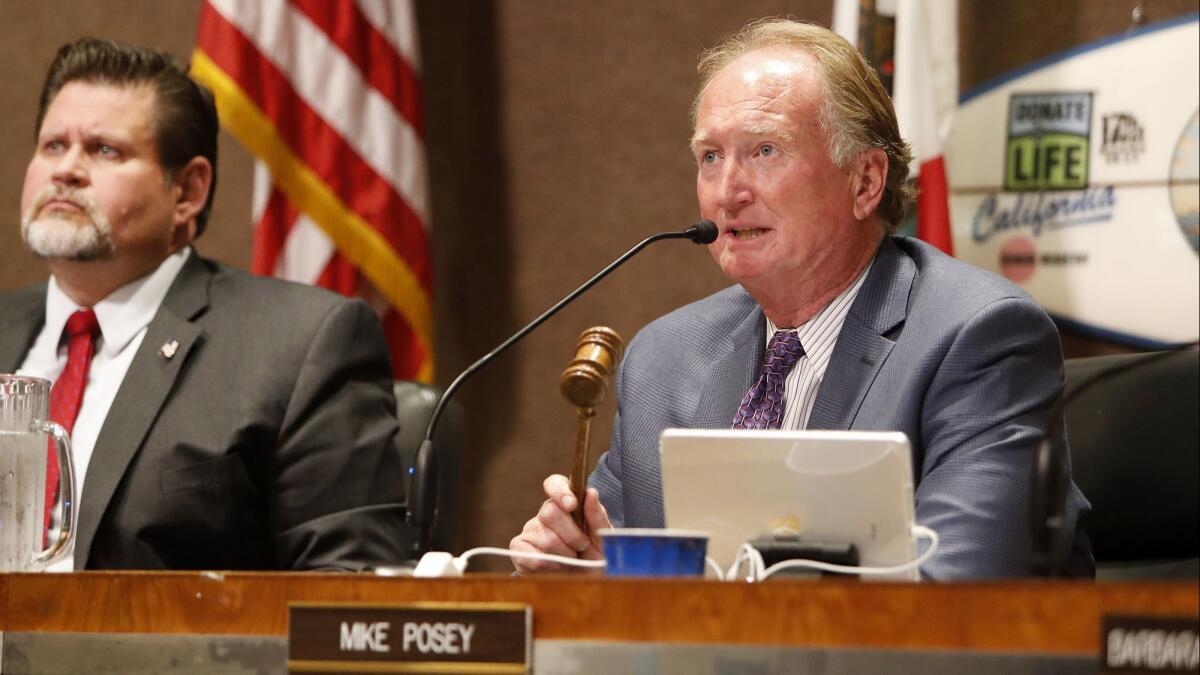 Huntington Beach Mayor Mike Posey asks the crowd for order during public comments regarding Senate Bill 54, the California "sanctuary state" immigration law, at Monday's City Council meeting.