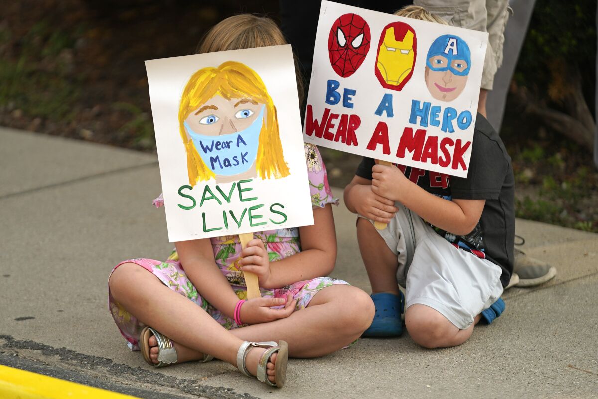 FILE - In this Aug. 6, 2021, file photo, Lucie Phillips, 6, and her brother David Phillips, 3, join parents and students during a rally at Utah State School Board Office calling for mask mandate in Salt Lake City. The mayor of Salt Lake City announced Friday, Aug. 20, 2021, that she had issued a mask order in the city's K-12 schools as the highly contagious delta variant of the coronavirus spreads. Mayor Erin Mendenhall said she used her emergency powers to issue the order and that she plans to work with health officials to determine when it can be lifted. (AP Photo/Rick Bowmer, File)