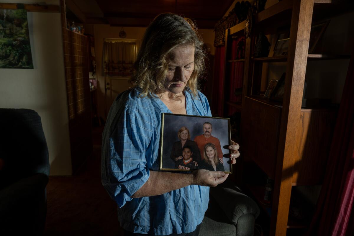 Brandi Michalik holds a family portrait that includes her parents and son, Neven Butler. 