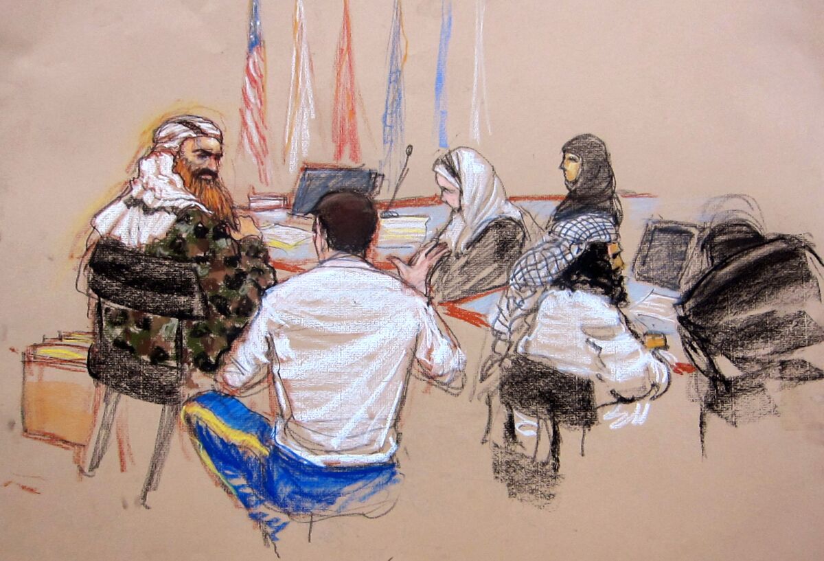 In this courtroom sketch, self-proclaimed terrorist mastermind Khalid Sheikh Mohammed, left, confers with his lawyer Army Capt. Jason Wright, second from left, at the Guantanamo Bay U.S. Naval Base in Cuba, Monday, Feb. 11, 2013.
