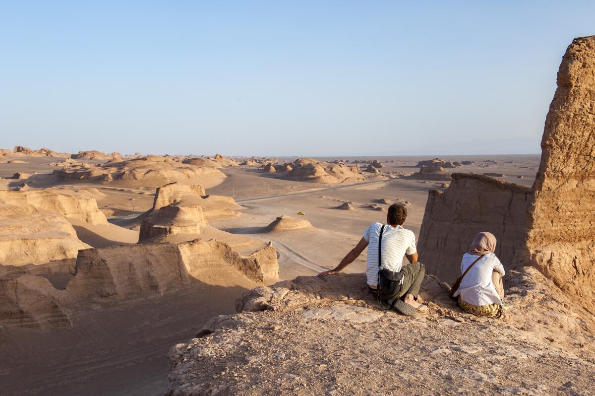 Tourists watch the sun go down over yardangs in the Lut Desert in Shahad, Iran. Known as kaluts in Iran, yardangs are geological formations that have been created by the dual action of wind and sand on rock. Lut is the world's 25th largest desert and a UNESCO World Heritage site.