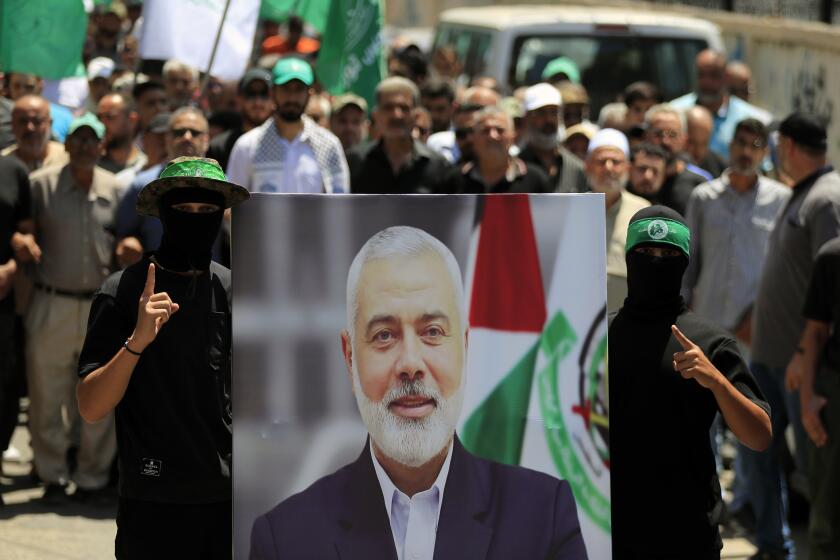 Miembros de Hamás sostienen una imagen del jefe político del grupo palestino, Ismail Haniyeh, durante una protesta para condenar su asesinato, en la ciudad de Tyre, en el sur del Líbano, el miércoles 31 de julio de 2024. (AP Foto/Mohammed Zaatari)