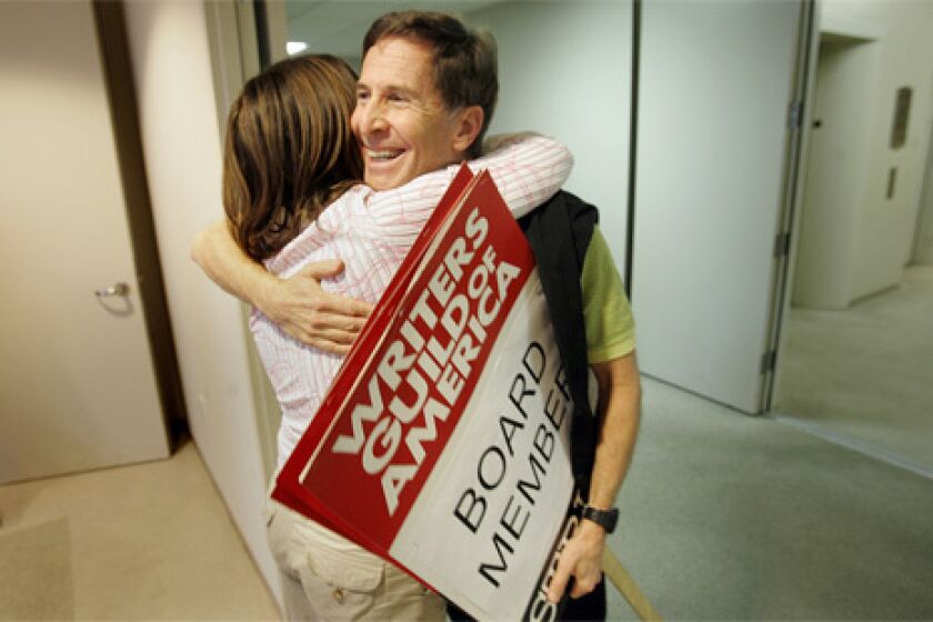 END IN SIGHT: Board members Robin Schiff, left and Tom Schulman embrace moments before a press conference announcing the potential end to the WGA strike.