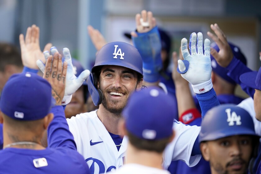 Los Angeles Dodgers' Cody Bellinger, center, smiles in the dugout