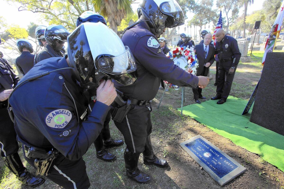LAPD motorcycle officers photograph the gravestone of Walter Kreps at Angelus-Rosedale Cemetery in Los Angeles. Kreps was the first LAPD motor officer killed in service, and the first LAPD officer killed in a traffic collision involving another police vehicle.
