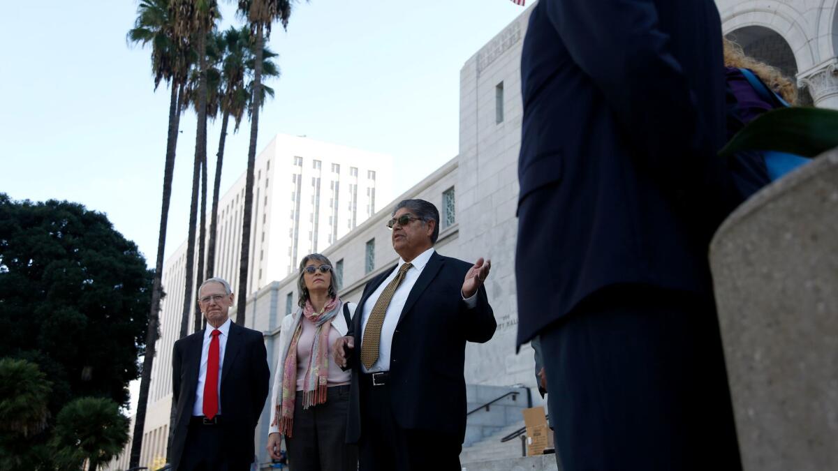Valley Village resident David Hernandez, center, speaks on the steps of City Hall about a proposed ballot initiative to repeal the city's RecycLA program, which covers roughly 70,000 customers. Opponents say the program has caused trash bills to skyrocket.