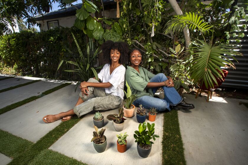SILVER LAKE, CA - JULY 28 2021: Jasmine Nicole, left, CEO of The Nice Plant, and Taylor Hartfield, head of marketing, are photographed in the courtyard of Nicole's home in Silver Lake. In foreground are some of the plants that they sell. (Mel Melcon / Los Angeles Times)