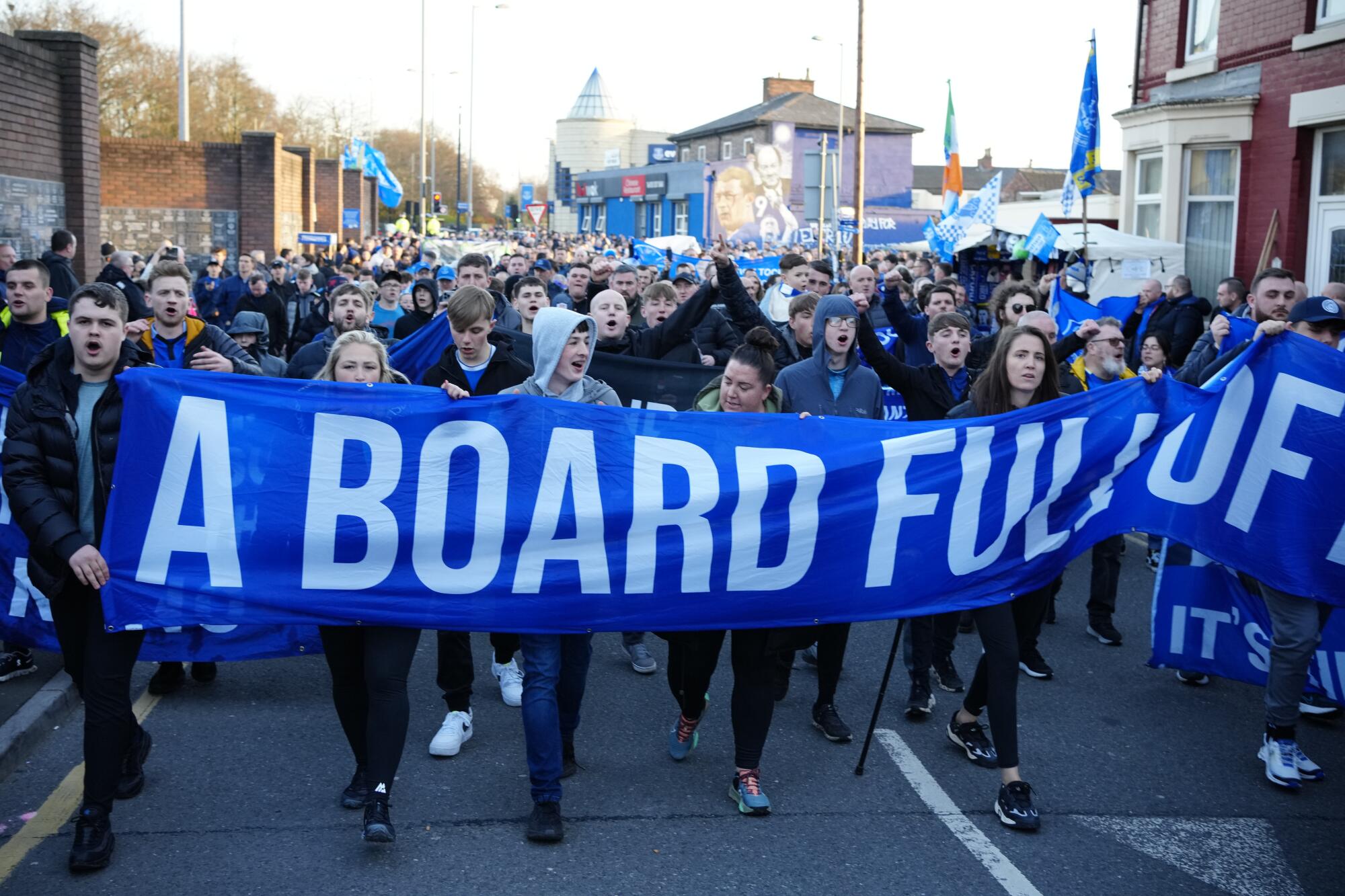 Everton supporters protest against the club's board as they make their way to a match.