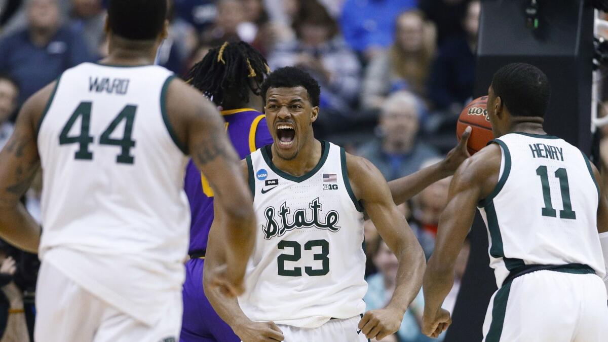 Michigan State forward Xavier Tillman (23) turns to looks at teammates Nick Ward (44) and Aaron Henry (11) after scoring against LSU during the first half of an East Regional semifinal in the NCAA tournament in Washington on Friday.