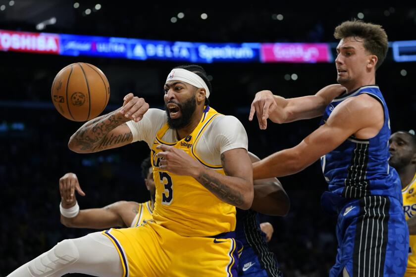 Los Angeles Lakers forward Anthony Davis, left, vies for a rebound against Orlando Magic forward Franz Wagner during the second half of an NBA basketball game, Monday, Oct. 30, 2023, in Los Angeles. (AP Photo/Ryan Sun)