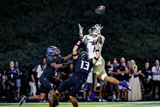 St. John Bosco's Madden Williams leaps to make catch between two Sierra Canyon defenders for 45-yard gain.