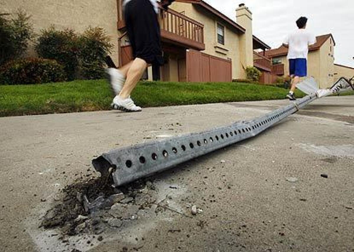 Joggers run past a broken street sign in 2009 after a deadly police pursuit left one dead and two people injured. Oscar Javier de la Torre Villalobos was convicted in the crash.