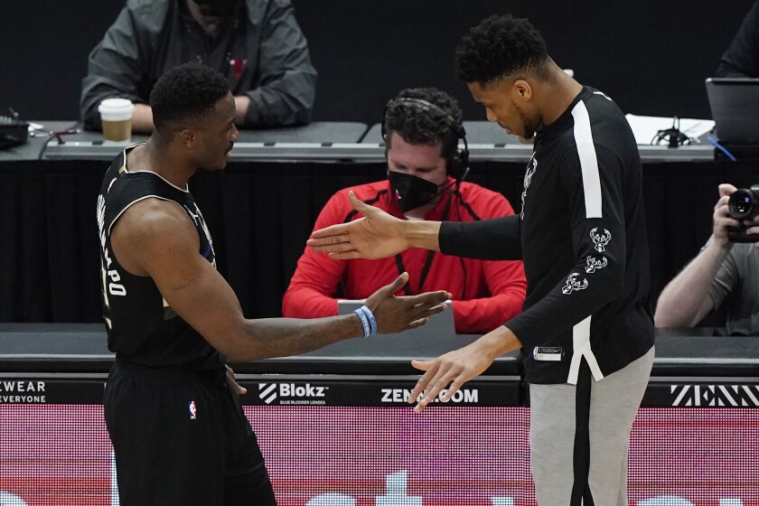 Milwaukee Bucks players Thanasis Antetokounmpo, left, and Giannis Antetokounmpo, right, give five before an NBA basketball game against the Chicago Bulls in Chicago, Sunday, May 16, 2021. (AP Photo/Nam Y. Huh)