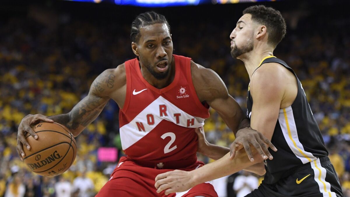 Toronto Raptors forward Kawhi Leonard handles the ball in front of Golden State Warriors guard Klay Thompson during Game 6 of the NBA Finals on June 13. The Clippers are still in the hunt for Leonard.