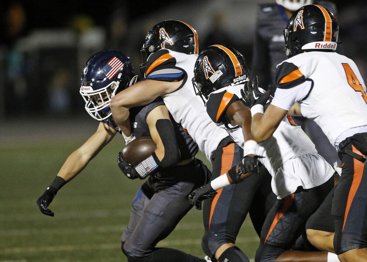 Newport Harbor's Jagger Blauwkamp (5) is cornered by a host of tacklers during Friday night's game.