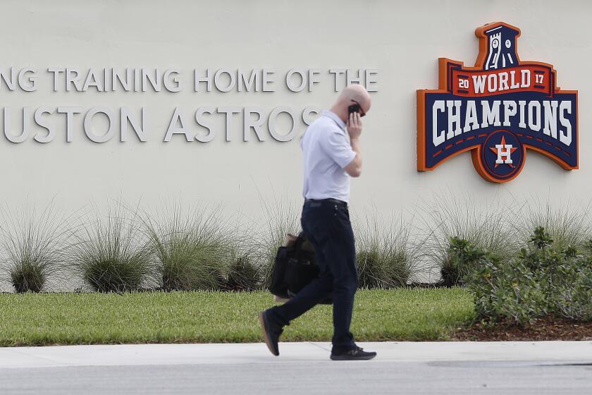 Houston Astros Senior Director of Business Operations Dan O'Neill walks past signs outside of the Houston Astros spring training baseball facility at the Fitteam Ballpark of The Palm Beaches, in West Palm Beach, Fla., Wednesday, Feb. 12, 2020. (Karen Warren/Houston Chronicle via AP)