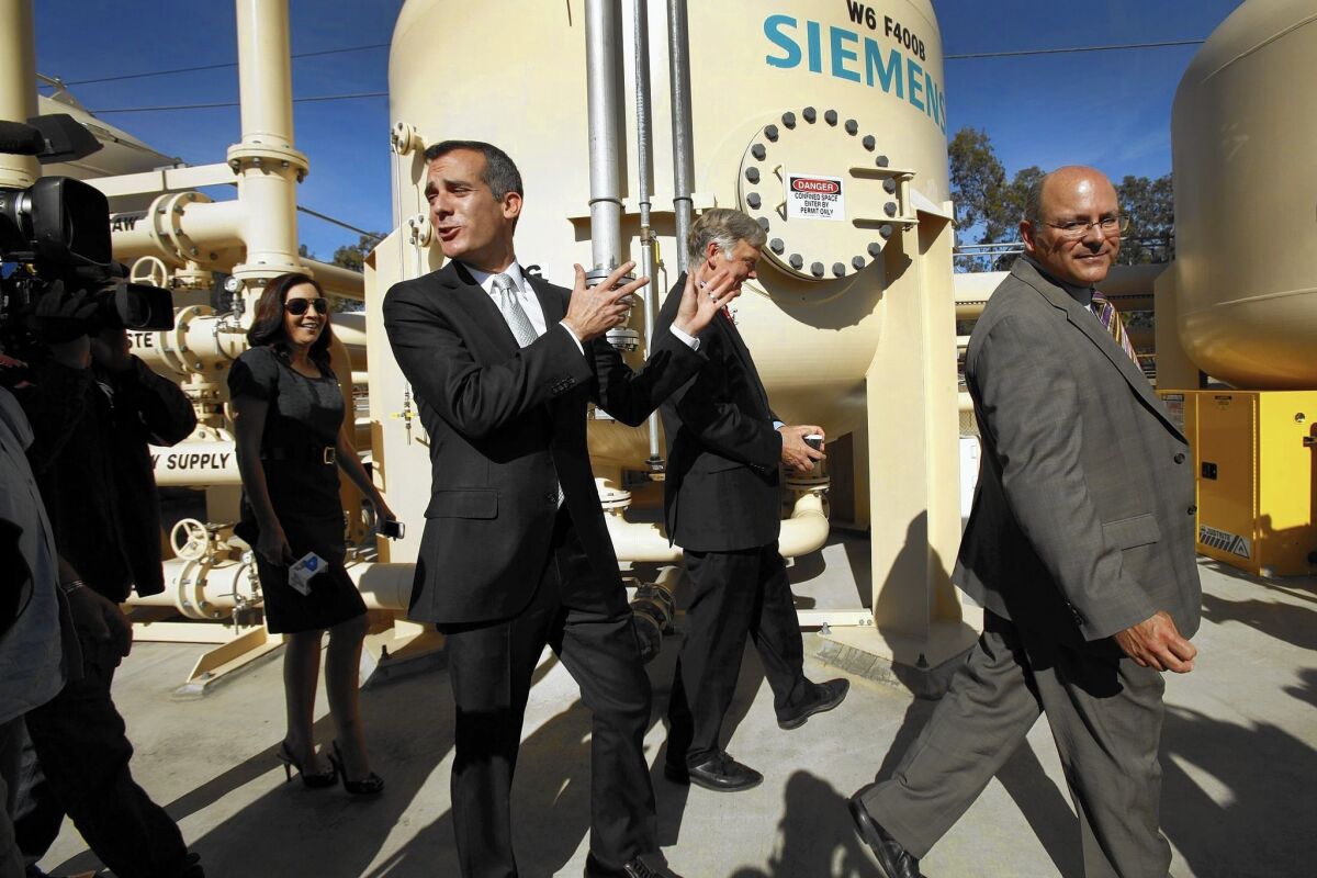 L.A. Mayor Eric Garcetti, center, walks with Department of Water and Power officials at an Arleta facility. Garcetti said when he took office in 2013 that he had a "clear mandate to reform" the agency.