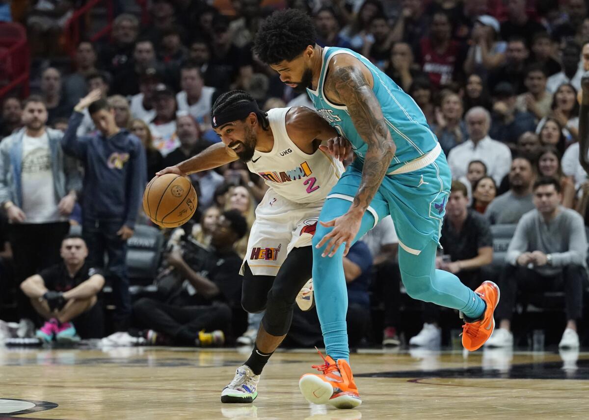 Charlotte Hornets center Nick Richards (4) defends Miami Heat guard Gabe Vincent (2) during the first half of an NBA basketball game Saturday, Nov. 12, 2022, in Miami. (AP Photo/Marta Lavandier)