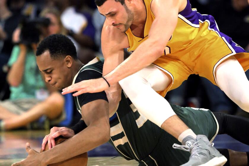 Milwaukee Bucks center John Henson and Lakers forward Larry Nance Jr. chase after a loose ball during the first half Friday night.