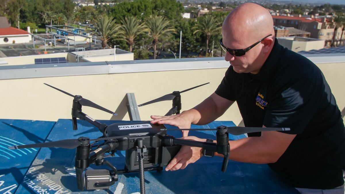 Standing on the roof launch pad at Chula Vista Police department, police officer/drone pilot Laurence Meyerowitz replaces a battery on a drone during a practice and training program on Jan. 18, 2019, in Chula Vista.