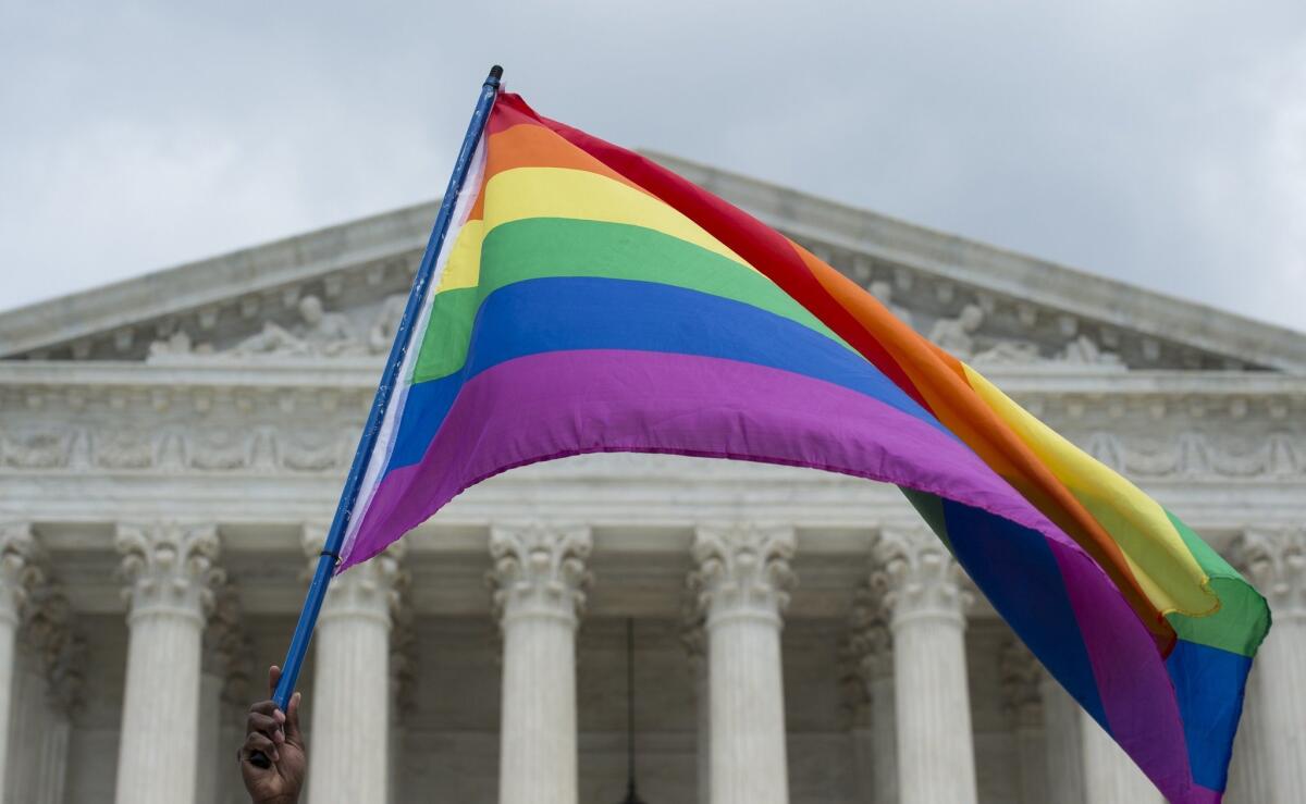 A rainbow flag is waved outside the Supreme Court in Washington, D.C., after the announcement about same-sex marriage.