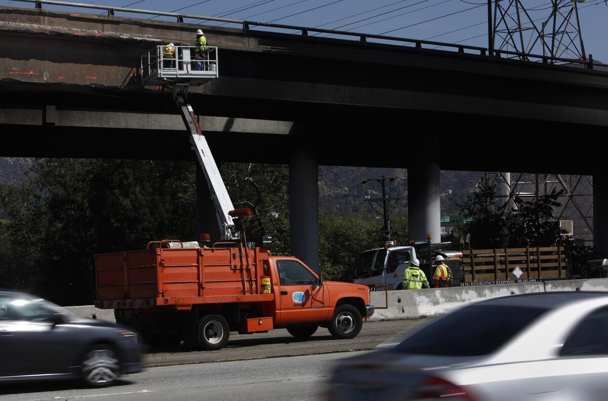 Caltrans workers inspect a transition road bridge over the 134 Freeway in Glendale. The bridge was not one of those identified in a state auditor's report on falsified testing data.
