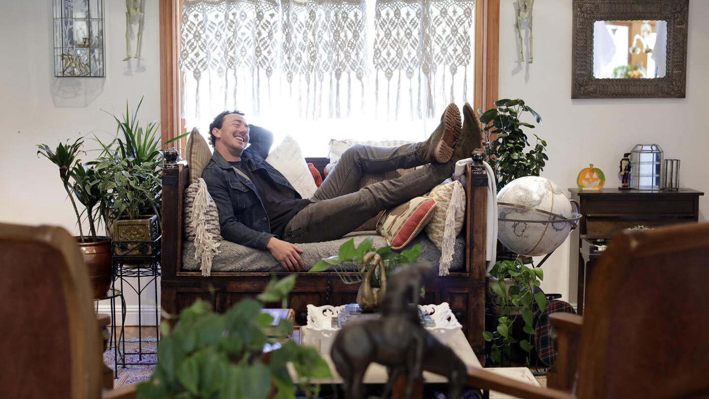 Actor Chris Coy's favorite room is his living room and adjacent kids' room. He enjoys lounging in his opium chair reading scripts. The space is decorated in "Alice's style" named for his wife. Wood and leather provide a warm, rustic feel.