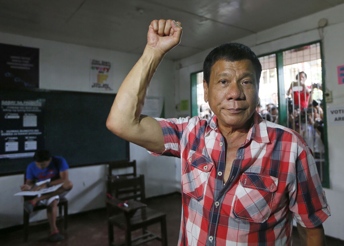 Front-running presidential candidate Mayor Rodrigo Duterte clenches his fist prior to voting in his hometown in Davao city on May 9, 2016.
