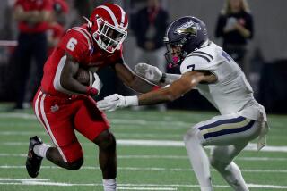 SANTA ANA, CALIF. - OPCT. 7, 2022. Mater Dei runnin bback Nathaniel Frazier tries to elude St.John Bosco defensive back Peyton Woodyard in the first half at Santa Ana Stadium on Friday night, Oct. 7, 2022. (Luis Sinco / Los Angeles Times)