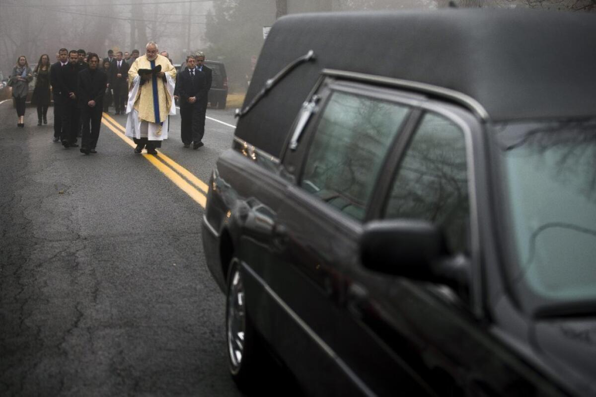 Mourners walk behind the hearse carrying the body of James Ferrari, one of four passengers killed Nov. 24 in a train derailment that federal investigators say could have been averted with recommended technology. Ferrari, of Montrose, N.Y., was buried Dec. 5.