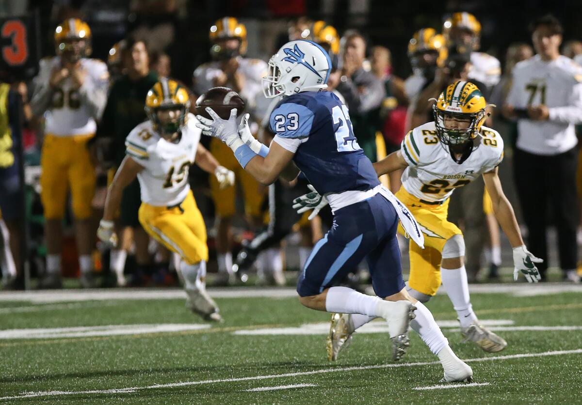 Zack Green (23) intercepts a pass and returns it 75 yards for a Corona del Mar touchdown in the first quarter of a Sunset League game against Edison on Friday.